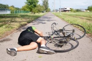 bicyclist lying on the ground with a bike