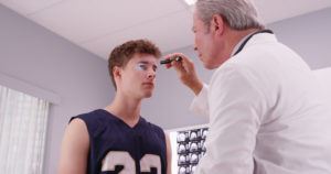 doctor checking patient’s eyes after a brain injury