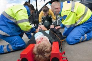 paramedics helping an accident victim with a head injury