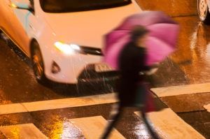 woman-walking-in-rain-about-to-be-hit-by-a-car
